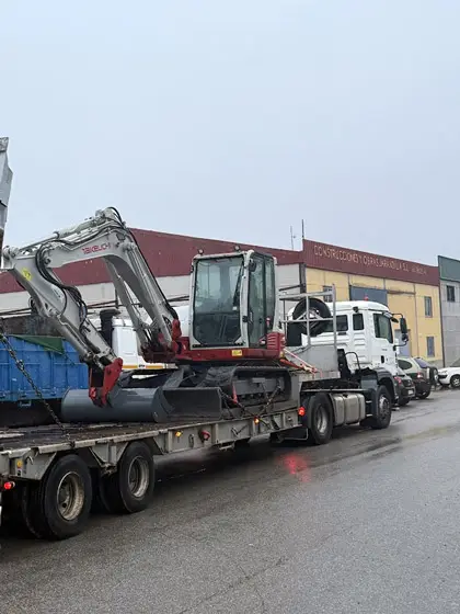 Retroexcavadora cargada para traslado a nueva obra.