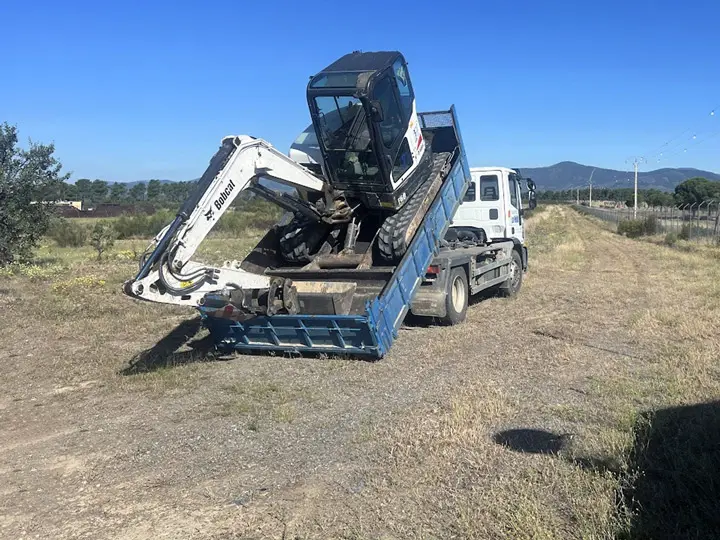 Transporte de miniexcavadora para labores de conservacion de caminos. Mejora la transitabilidad y el drenaje del camino.