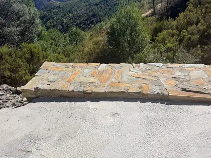 Aleta de mamposteria en obra de drenaje transversal bajo camino. Cumple normativa hidráulica y criterios de calidad del agua.