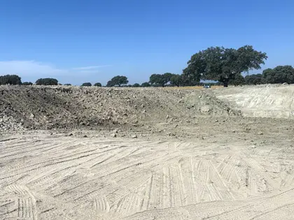 Excavacion y desmonte de balsa de agua con conformacion de taludes. Cumple normativa hidráulica y criterios de calidad del agua.