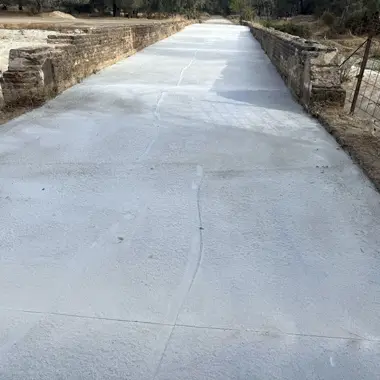 Camino de hormigon sobre alcantarilla de drenaje con pendientes controladas. Cumple normativa hidráulica y criterios de calidad del agua.