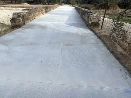 Camino de hormigon sobre alcantarilla de drenaje con pendientes controladas. Cumple normativa hidráulica y criterios de calidad del agua.